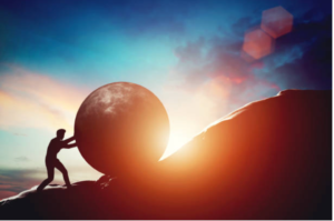 Silhouette of a person pushing a giant ball up a hill at sunset, with warm orange light behind them.
