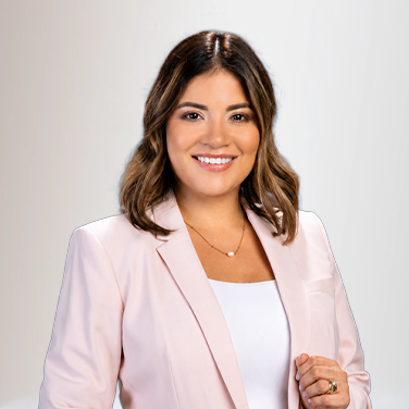 Smiling woman in a light pink blazer and white top, facing the camera in a professional headshot.