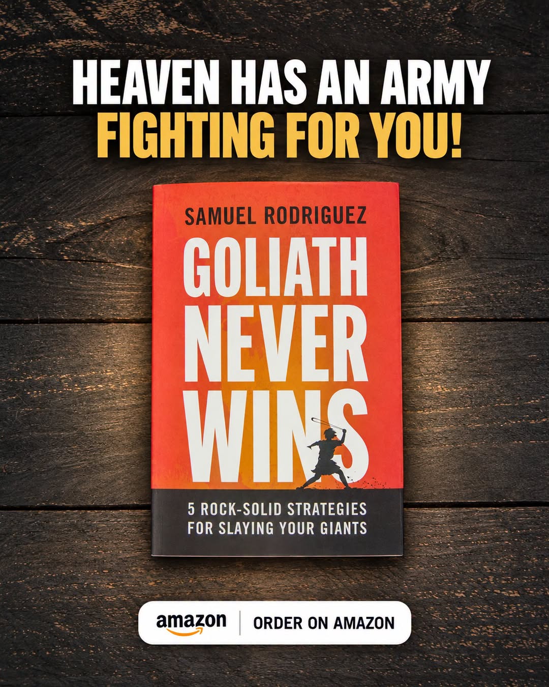 Book cover for 'Goliath Never Wins' by Samuel Rodriguez on a dark wooden surface; banner above reads 'HEAVEN HAS AN ARMY FIGHTING FOR YOU!' with an 'Order on Amazon' badge beneath the book.